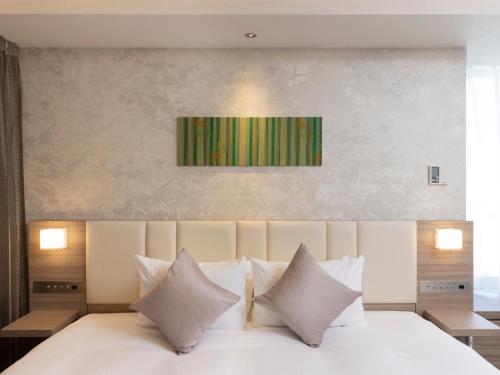 札幌札幌格兰大酒店的卧室配有白色的床铺和白色的枕头