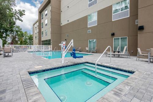 阿拉楚阿Holiday Inn Express & Suites Alachua - Gainesville Area, an IHG Hotel的大楼前带滑梯的游泳池