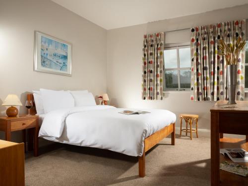 沃特福德Faithlegg Self Catering Mews的卧室设有一张白色大床和一扇窗户。