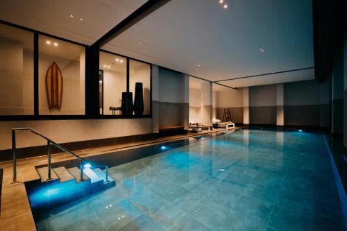 卡德赞德-班得斯特兰德酒店的一座大型游泳池,位于一座带窗户的建筑内