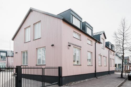 纳坦利Luxury Apartment Hovi的前面有黑色围栏的粉红色房子
