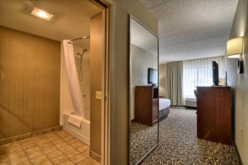 科特兰Clarion Inn & Suites - University Area的酒店客房设有淋浴和一间卧室。