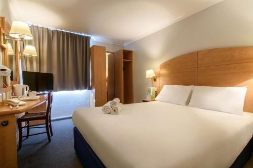 利物浦利物浦钟楼酒店的酒店客房设有一张大床和一张书桌。