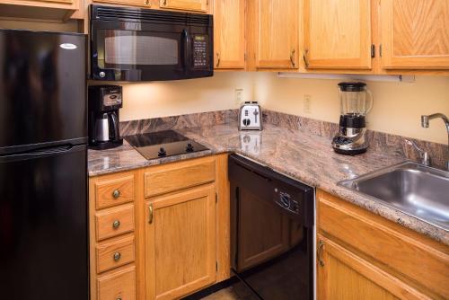 圣达菲圣达菲钻石度假村公寓式酒店的厨房配有黑色冰箱和水槽