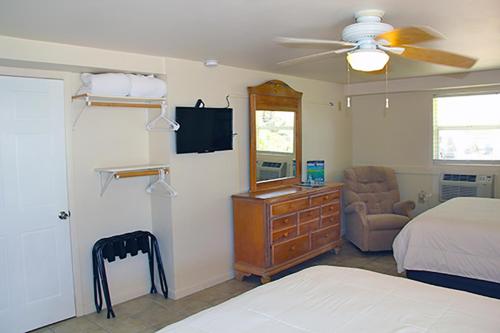小图奇凯Parmer's Resort的一间卧室配有一张床、一个梳妆台和电视。