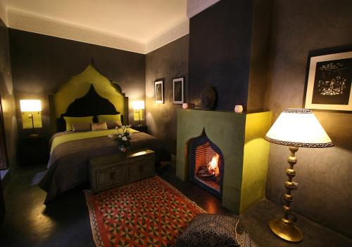 马拉喀什达尔贝加住宿加早餐旅馆的一间卧室设有一张床和一个壁炉