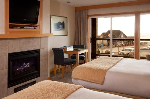 太平洋城基万达海角宾馆的酒店客房设有两张床、一个壁炉和一台电视。