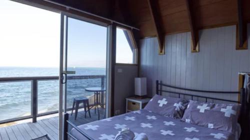 耐莉湾Nomads Magnetic Island的一间卧室设有一张床和一个海景阳台