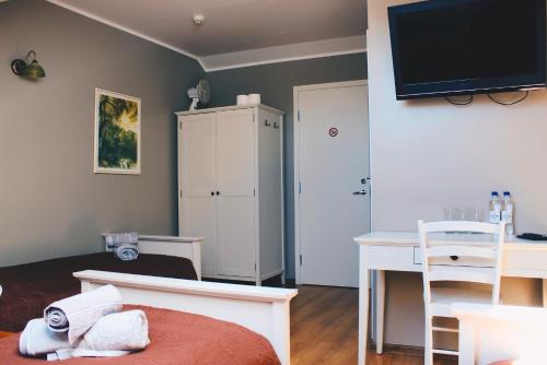 沃鲁莫爱萨艾特宾馆的一间卧室配有一张床、一张书桌和一台电视。