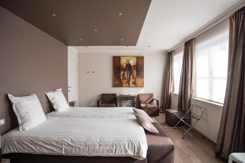 波佩林赫Hotel de la Paix的一间卧室配有一张大床和一把椅子
