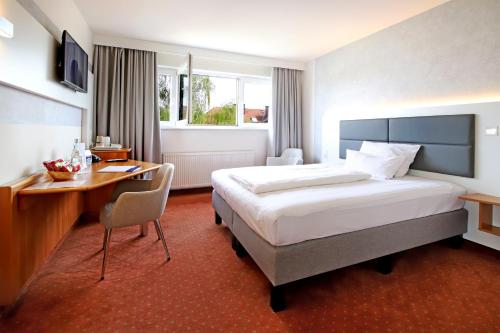 新伊森堡法兰克福机场郁金香酒店的酒店客房设有一张大床和一张书桌。