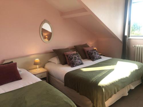 Saint-Leu-dʼEsserent乐瓦兹酒店的一间卧室配有两张床和镜子