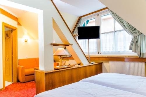 格拉茨附近卡尔斯多夫彭德尔酒店的一间酒店客房,配有一张床和一台电视