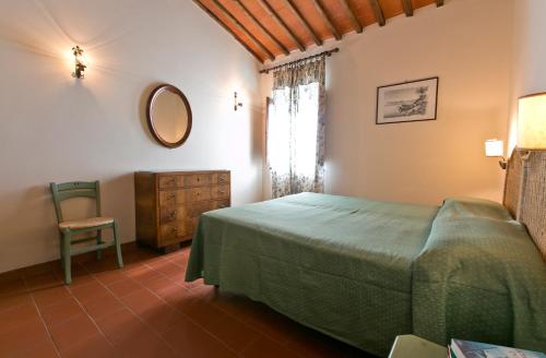 波吉邦西Agriturismo il Torrione的一间卧室配有一张床、一把椅子和镜子