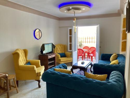 西迪基里尔Seaside Two-Bedroom Chalet Sidi Krir的客厅配有蓝色的沙发和椅子