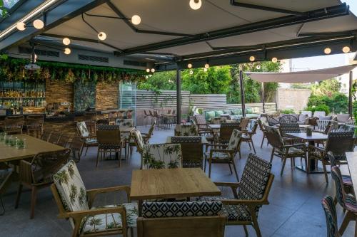 雅典巴尔米拉海滩酒店的一间空餐厅,配有桌椅和庭院