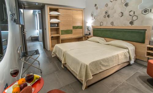 雅典巴尔米拉海滩酒店的一间卧室配有一张床和一张桌子及一碗水果