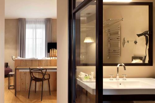 都灵都灵卡利娜广场NH集团酒店的一间带水槽的浴室和一间带桌子的厨房