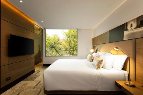 波哥大EK Hotel By Preferred Hotels Group的一间卧室设有一张大床和大窗户