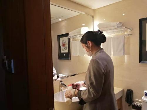 Jiangning南京东航华美达酒店的洗手在浴室水槽里的女人