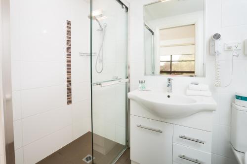 纽卡斯尔查尔斯敦公寓的白色的浴室设有水槽和淋浴。