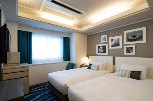 横滨新横滨格雷斯酒店的酒店客房设有两张床和电视。