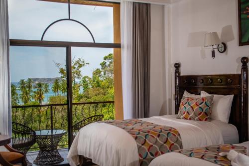 曼努埃尔安东尼奥圣八达度假酒店及水疗中心的一间卧室设有两张床和一个美景阳台