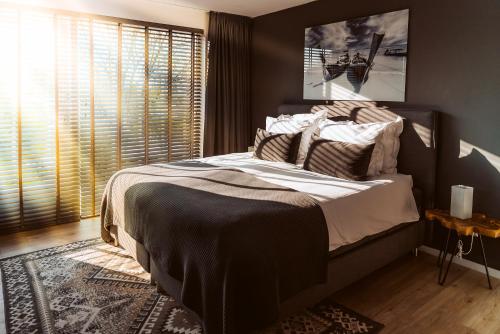 布莱斯韦克B&B Bleiswijk的一间卧室设有一张大床和一个窗户。