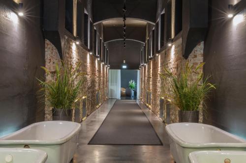 派尔努赫敦温泉酒店的浴室的墙壁上设有两个浴缸和植物