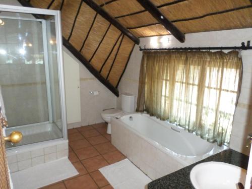 比勒陀利亚Foundry Guest Lodge的带浴缸、卫生间和盥洗盆的浴室