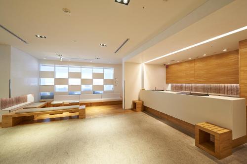 长野Sotetsu Fresa Inn Nagano-Zenkojiguchi的大型客厅设有大窗户和桌子