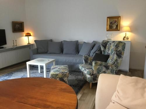 霍尔斯泰因地区诺伊斯塔特Held Ursel的客厅配有蓝色的沙发和两把椅子