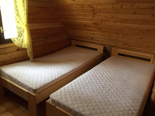 纳尔提Domek przy plaży的配有窗户的小木屋内的两张床
