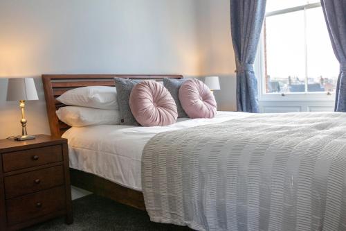 阿什伯恩Dovedale的卧室配有带枕头的床铺和窗户。
