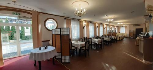 热舒夫Hotel TWIERDZA的用餐室设有桌椅和窗户。