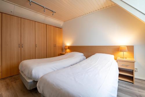 哈林亨阿米纳姆酒店 - 迷人的城市旅馆的卧室设有2张床和木橱柜。