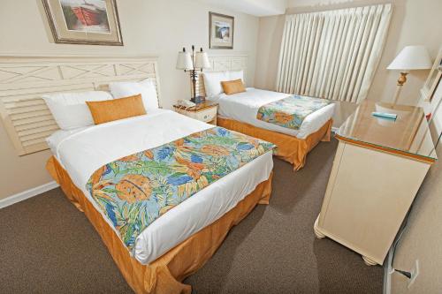 默特尔比奇大西洋度假村的酒店客房设有两张床和一张桌子。