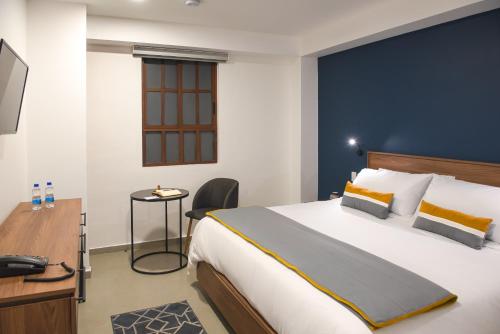 墨西哥城Hotel Boutique Parque Centro的酒店客房设有一张大床和一张书桌。