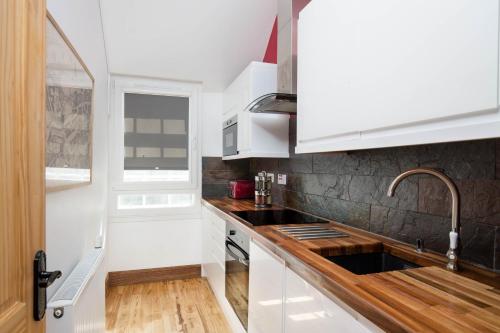 爱丁堡Castle Vista, Grassmarket Apartment的厨房配有白色橱柜和水槽