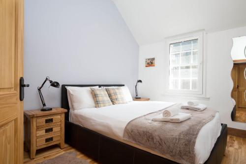 爱丁堡Castle Vista, Grassmarket Apartment的一间卧室设有一张床和一个窗口