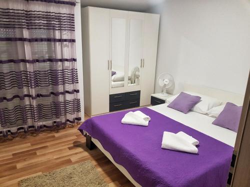 Kaštel SućuracApartman Nela的卧室配有紫色和白色的床和镜子