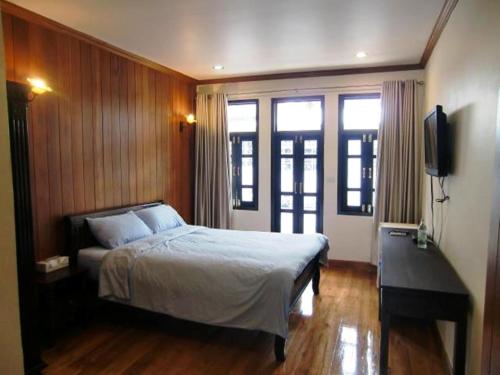 曼谷皇家查亭度假村酒店的一间卧室配有一张床和一台平面电视