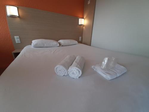 尚特马坎苏迪普瑞米尔经典酒店的一张带两条毛巾和两个枕头的床