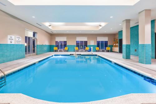 佩里斯堡Holiday Inn & Suites - Toledo Southwest - Perrysburg, an IHG Hotel的蓝色瓷砖的酒店客房内的大型游泳池