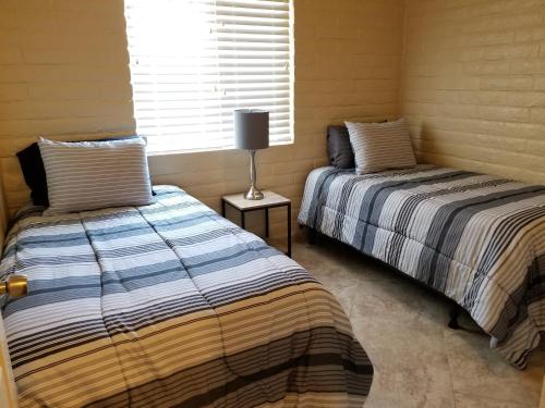 土桑Tucson Airport Oasis的两张睡床彼此相邻,位于一个房间里
