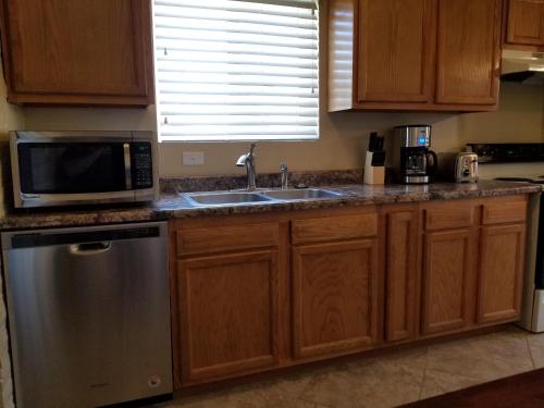 土桑Tucson Airport Oasis的厨房配有水槽和微波炉