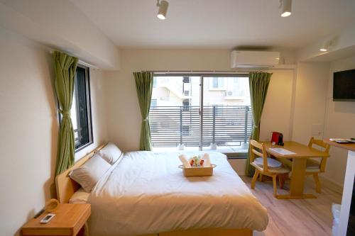 东京Jeffery Skytree Residence Tokyo的一间卧室配有一张床、一张书桌和一个窗户。