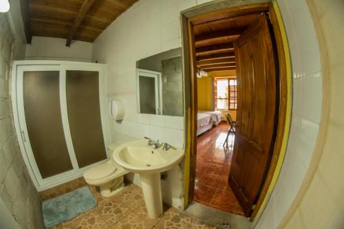 危地马拉欧罗旅馆的一间带水槽、卫生间和镜子的浴室