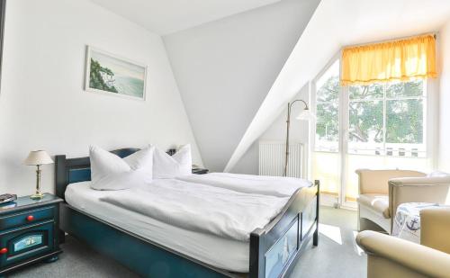 萨斯尼茨海之宴酒店的卧室配有床、椅子和窗户。
