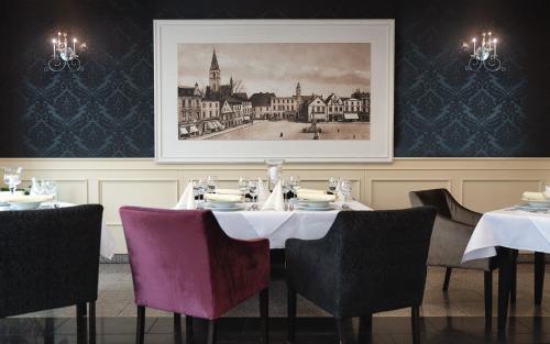 OlesnoHotel Olesno的用餐室配有桌椅和图片